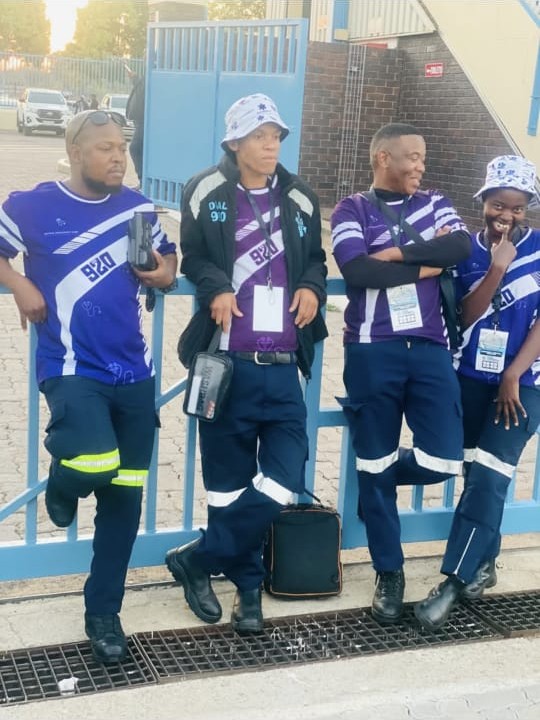 Four medics in purple 920 shirts at a stadium gate